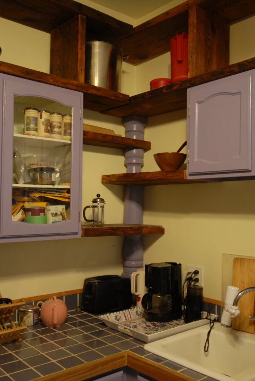 a kitchen with lots of wooden shelves and purple cabinets