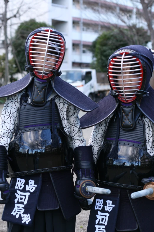 two asian people in full armor on a street