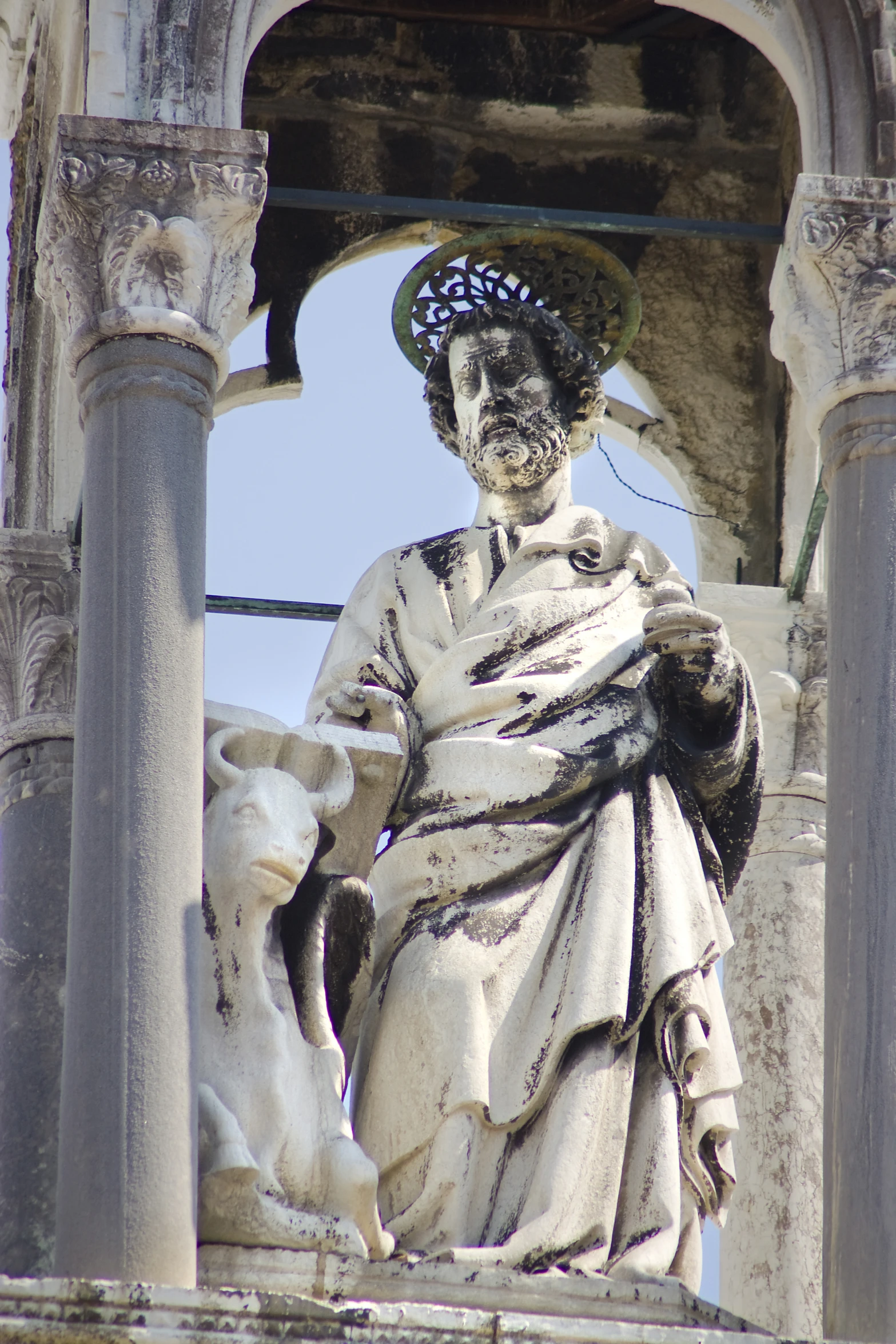 the statue is in a niche between the columns