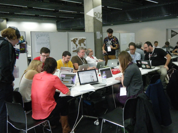 a group of people in business attire look at laptops