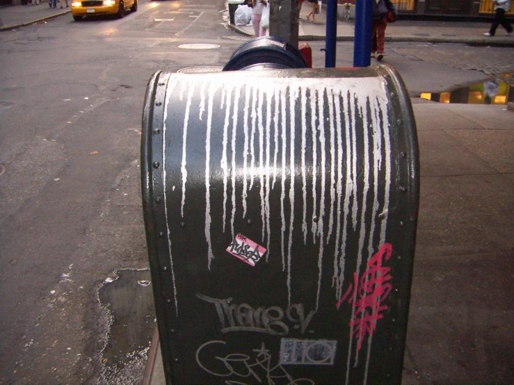 graffiti on a mailbox that is sitting by the curb