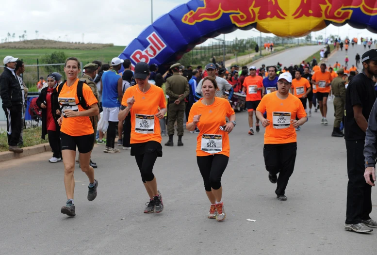 a group of runners run along a road