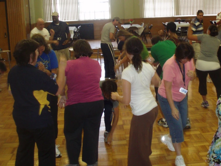 a group of people are dancing on the wooden floor