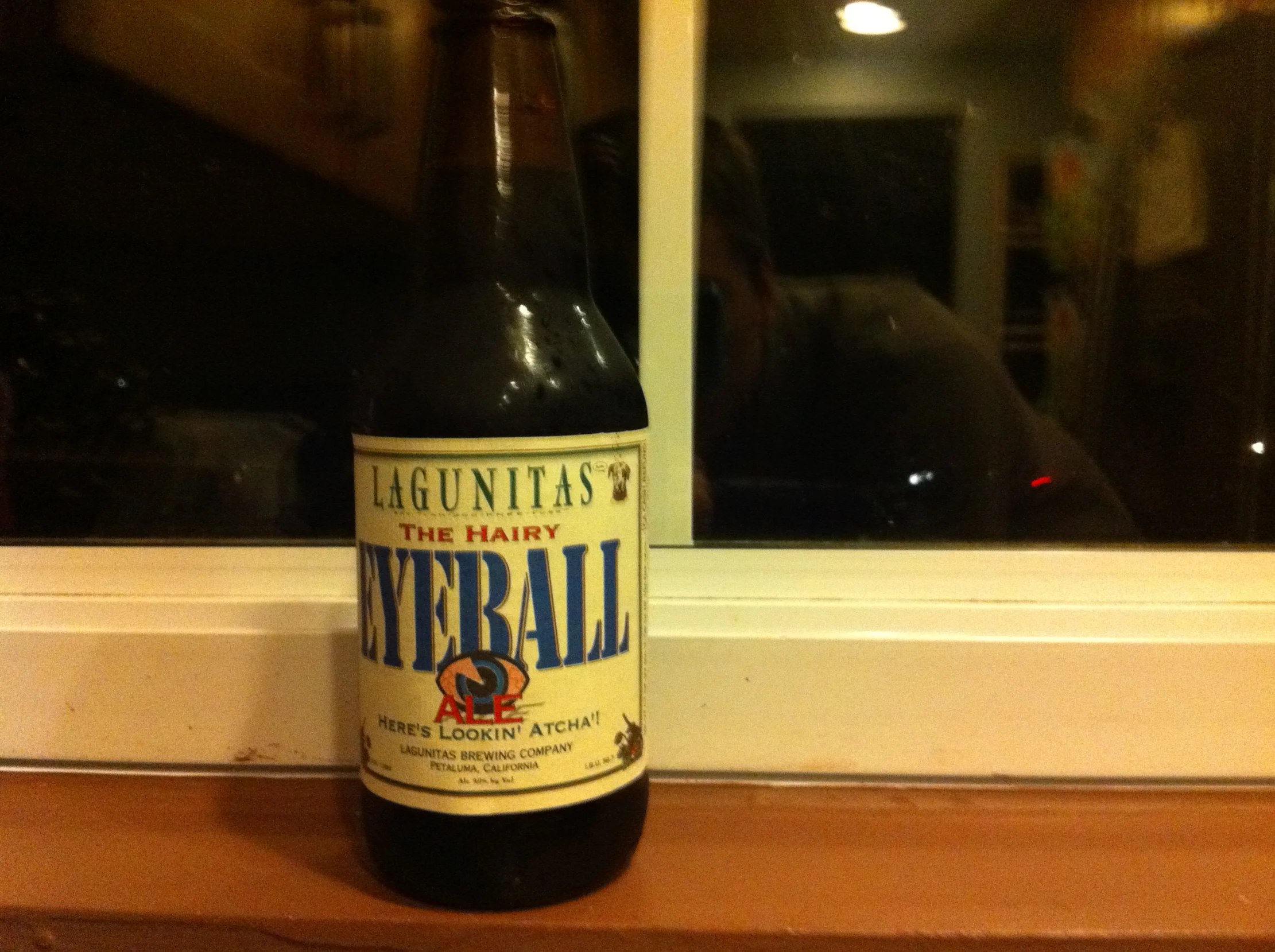 an old bottle of beer sitting in front of a window