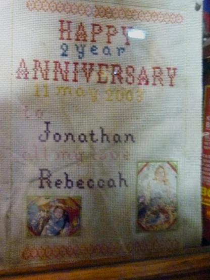 cross stitch sample of a wedding anniversary with two pictures and date