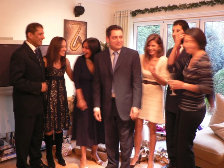 a group of people in a living room smiling and talking