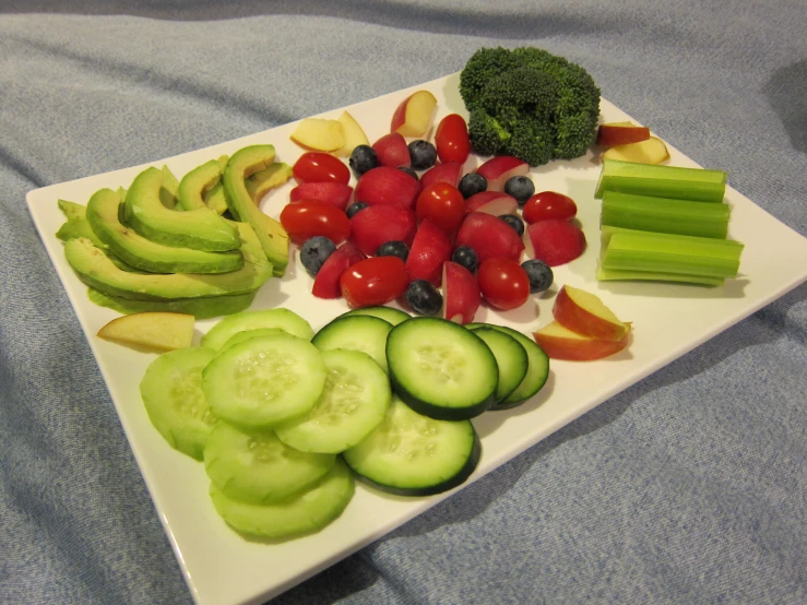 a square plate of cut up vegetables with the rest of some cut up vegetable