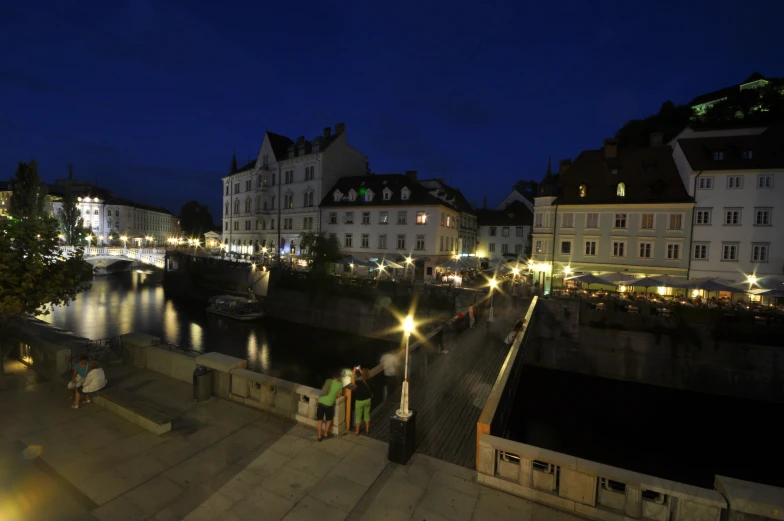 a number of people near some buildings and a river