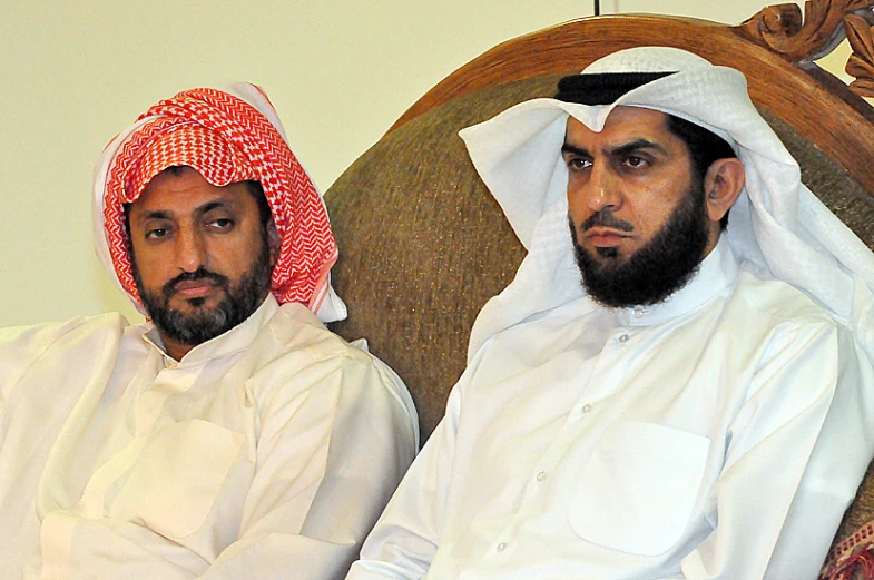 two arab men sitting down in formal clothing