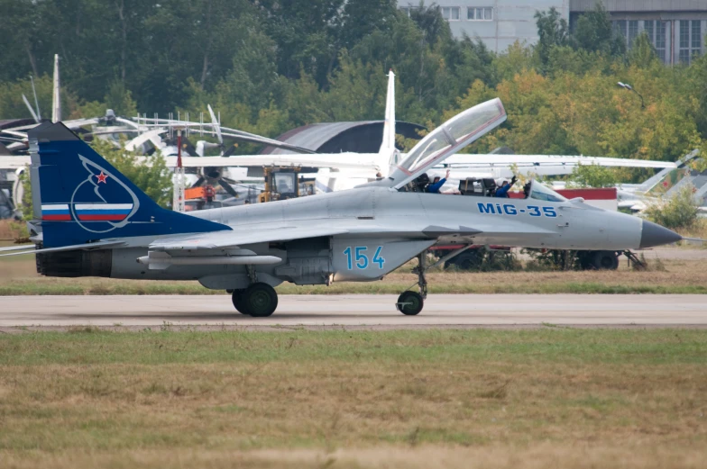 a gray and blue jet on top of a runway