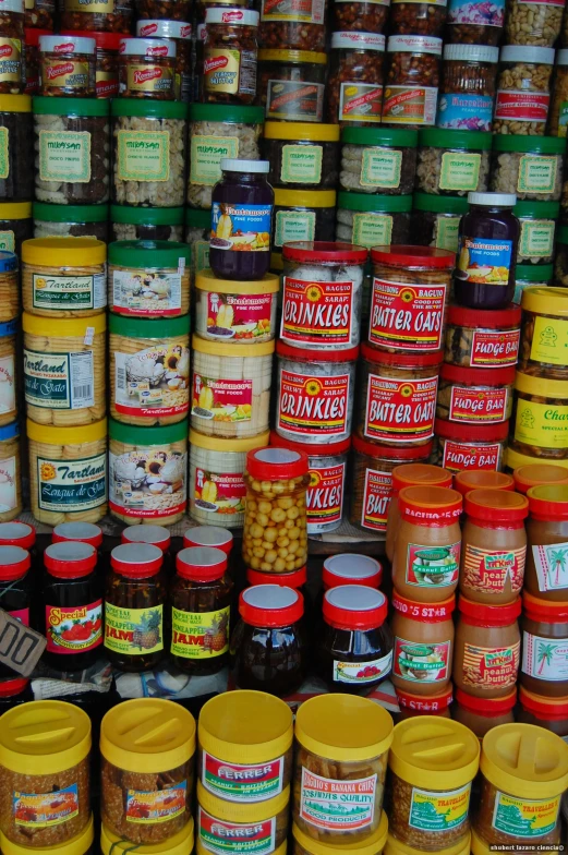 many jars and containers filled with food sitting on a shelf