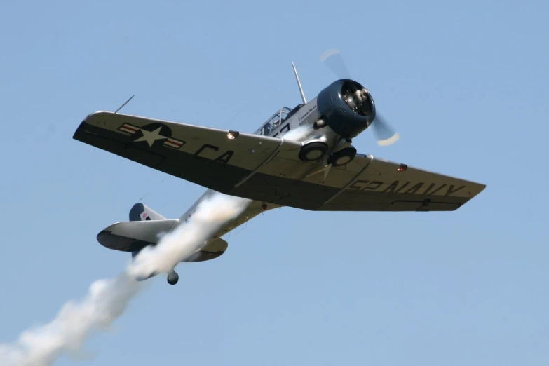 an airplane flying in the sky with smoke trailing from its tail