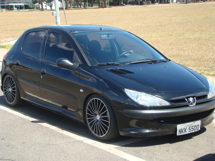 a small black car parked on the side of a road