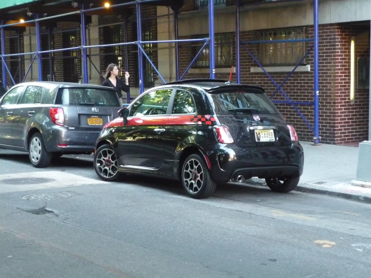 several cars parked on a side walk next to a building