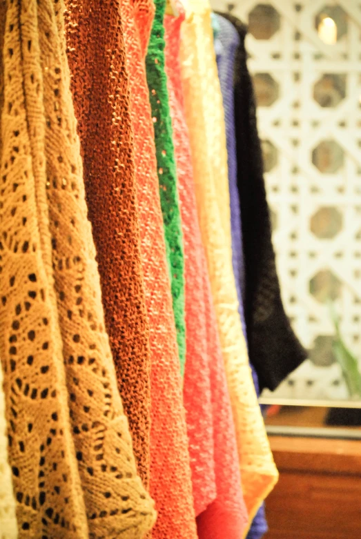 colorful shawls hanging on a line in the store