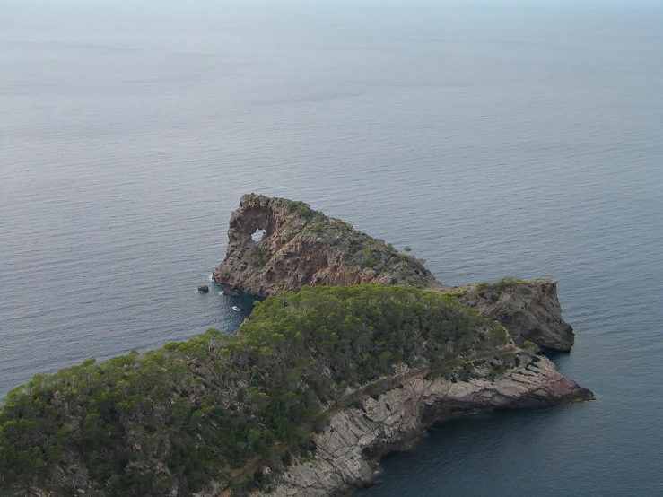 the large rock formation is on the shore of the water