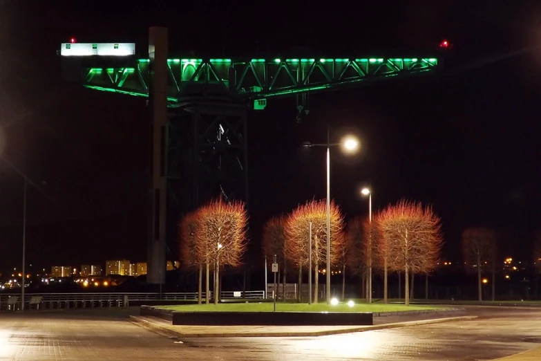 a green bridge over some grass at night