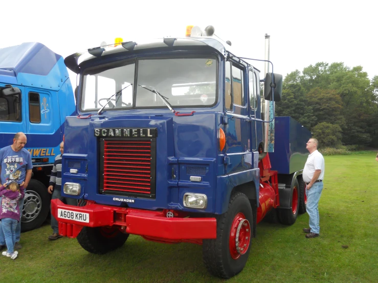 a large blue truck is parked in the grass