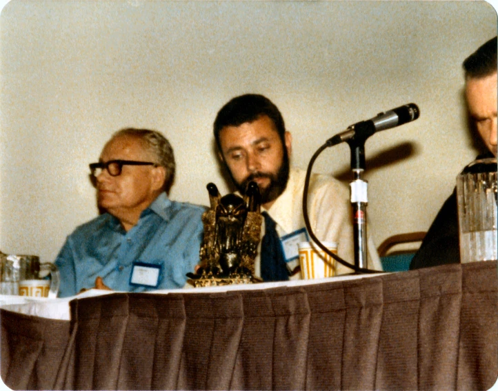 three people sitting next to each other at a table