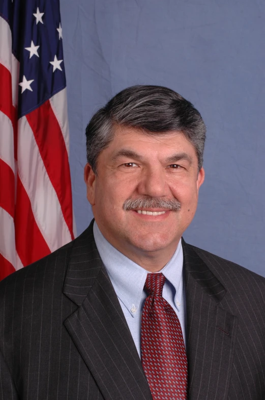 a close up of a person wearing a suit and tie