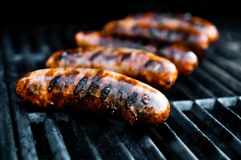 three  dogs are being cooked on a grill