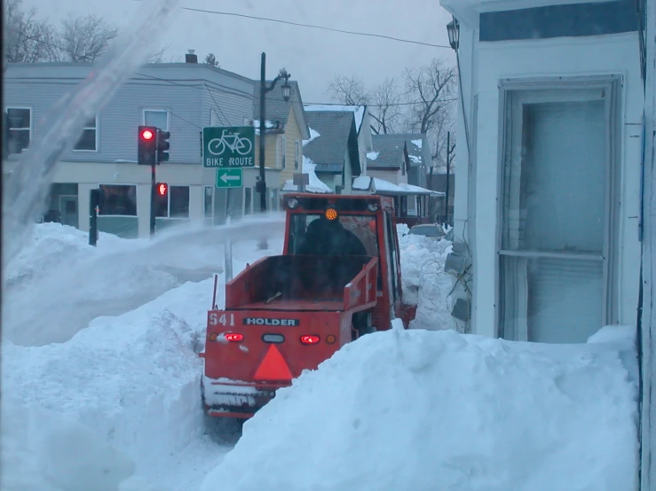 a red truck parked in front of a pile of snow