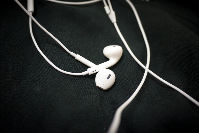 a pair of white earbuds are laying down