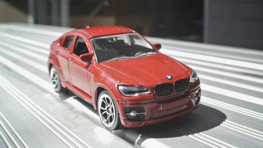 toy red car model sitting on white and gray background