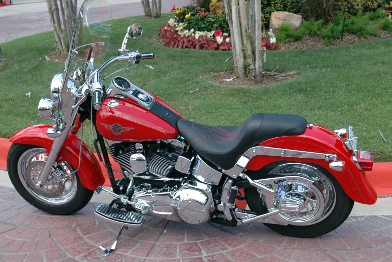 a red motorcycle parked on the road in front of some trees