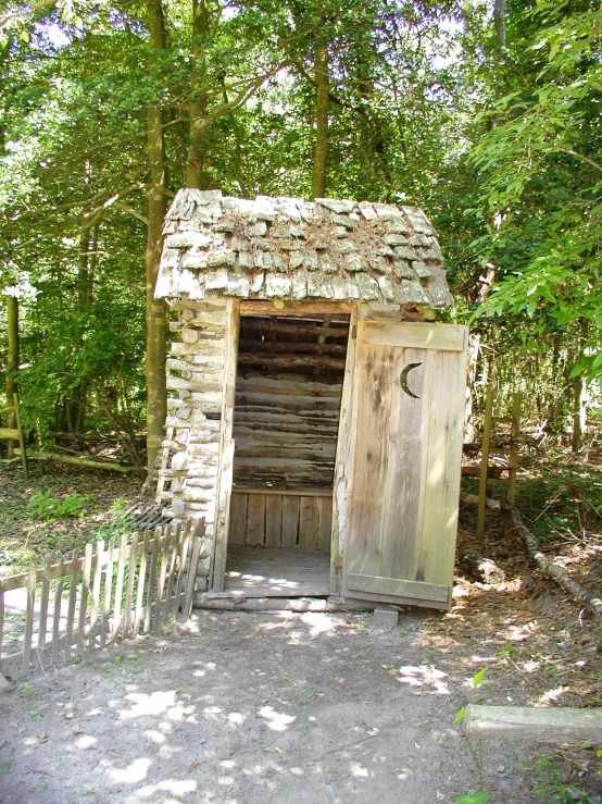 there is a building in the woods with a gate