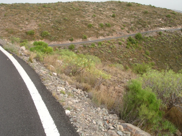 a road that has a car on it by some grass