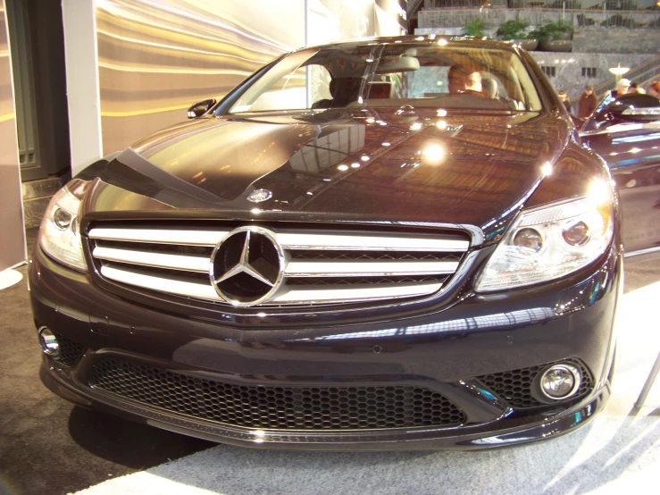 a black car sits on display at an automobile show