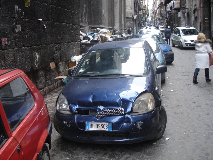 a car in a street with a person walking past