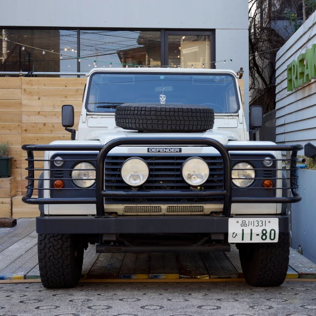 a large white vehicle sits parked on top of the street