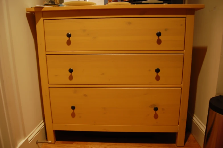 a wooden dresser with three drawers and s