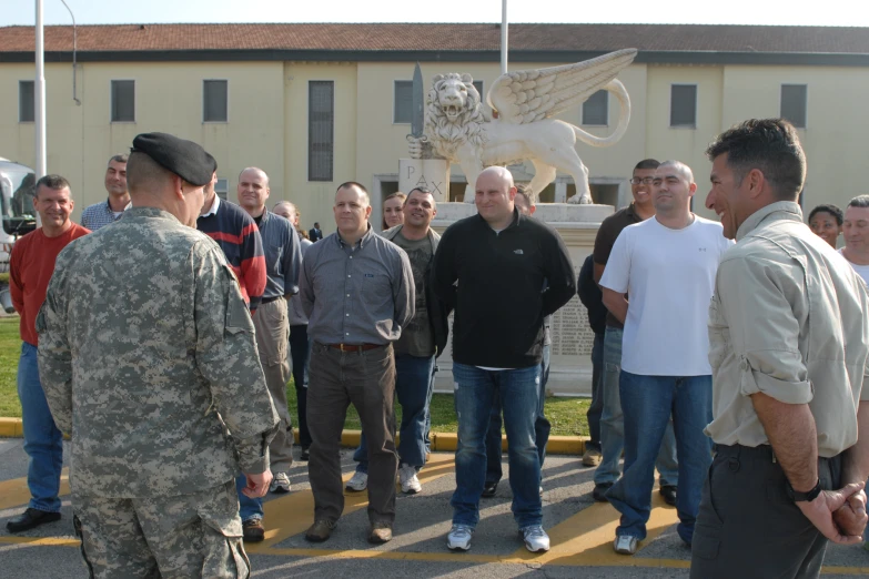 group of men standing around a memorial busturizer