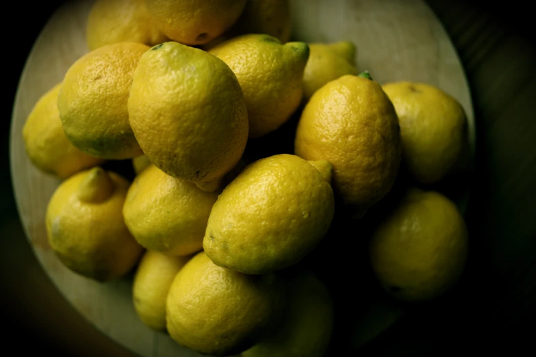 a bowl filled with lemons sitting next to each other