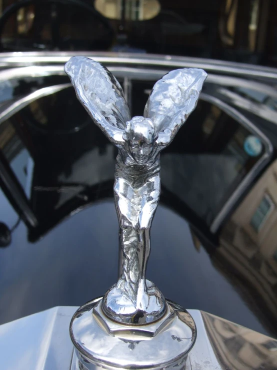 an old car with a fancy silver object on the hood