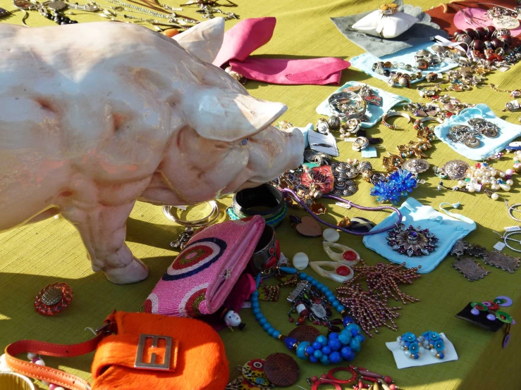 a table is covered with beads, celets and animal statue