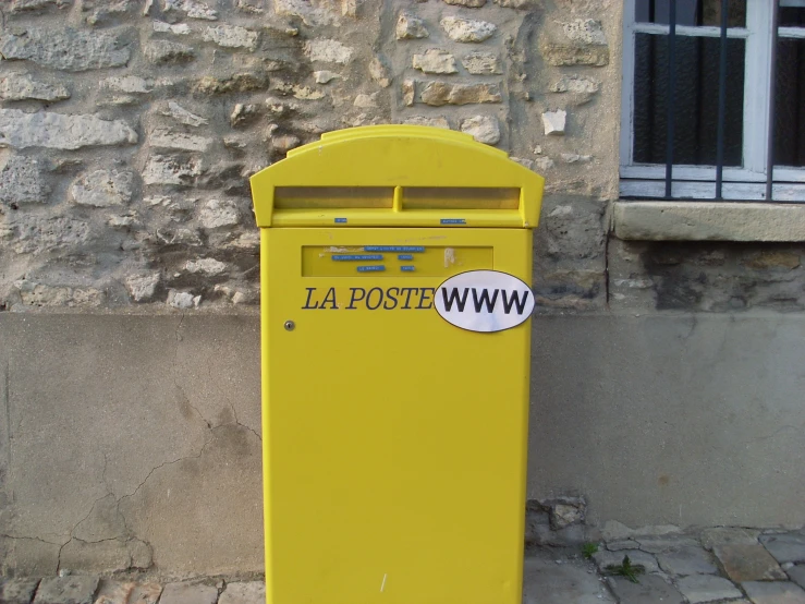 a yellow mailbox sitting outside of a brick building