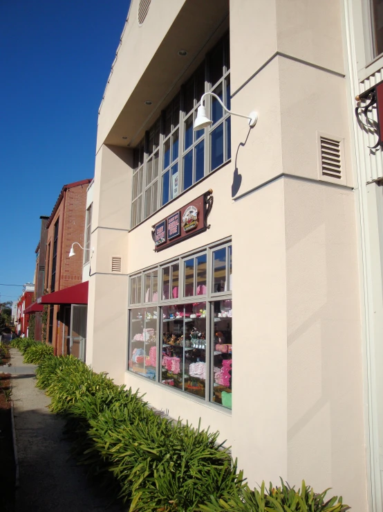 front of the building with many signs and flowers