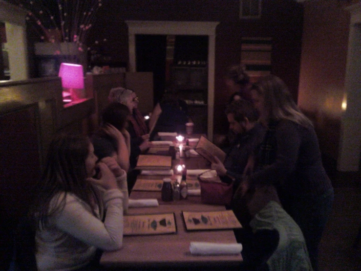 a group of people sitting at a long table next to each other