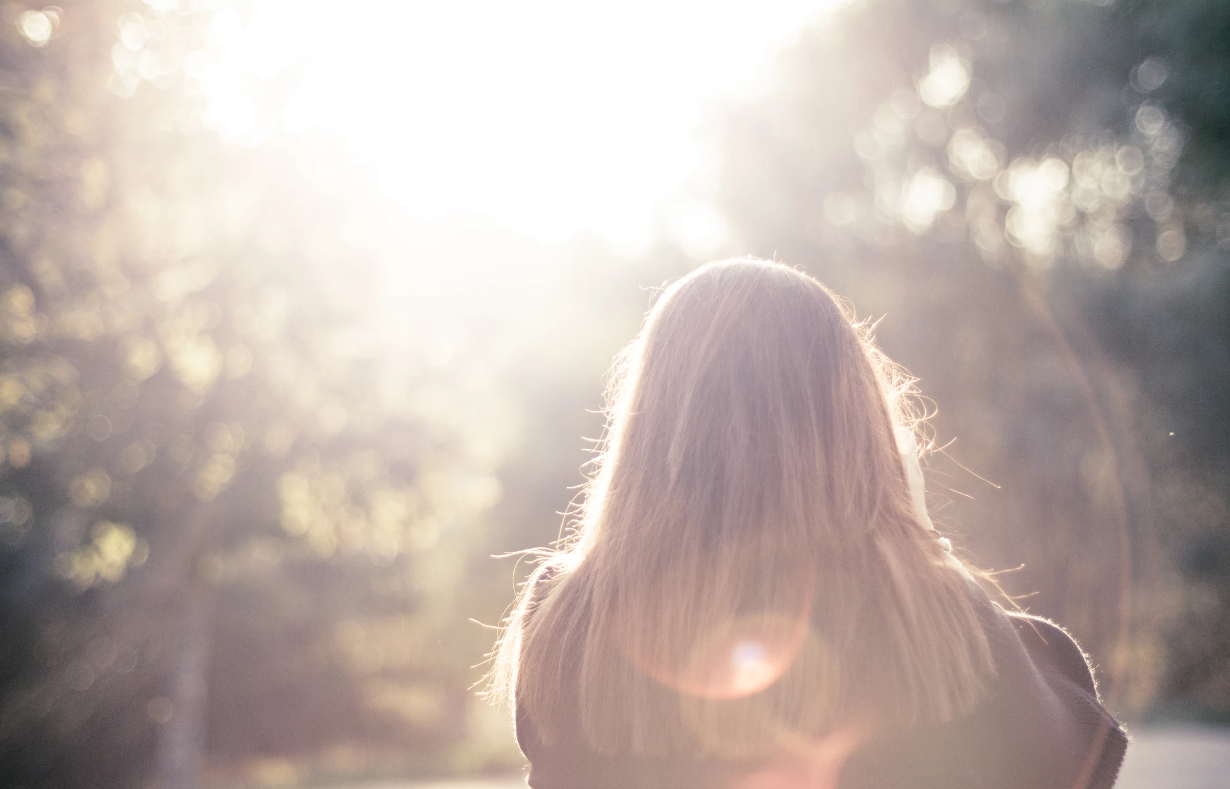 a woman's long hair is looking down at her phone