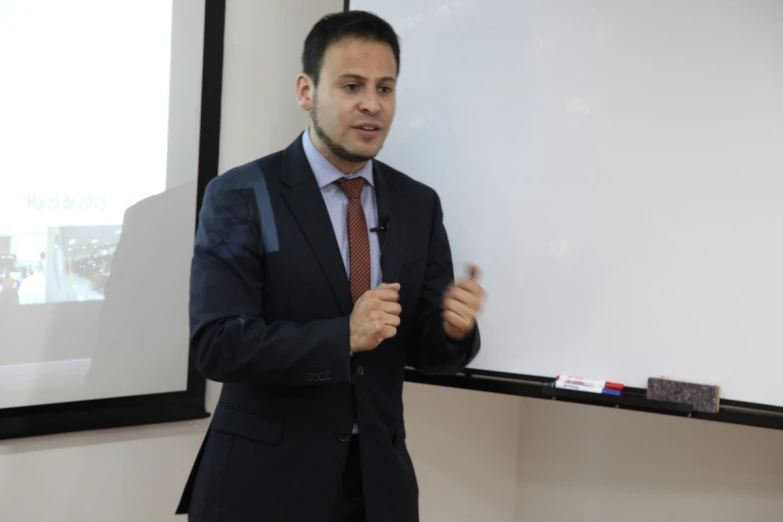 a man in a suit standing next to a board