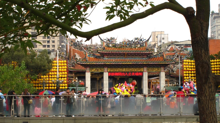 people with asian umbrellas and decorations standing in front of a building