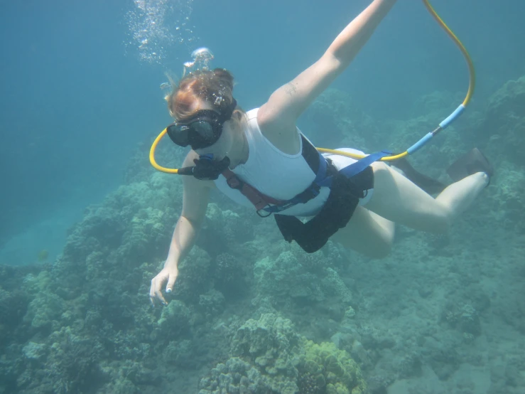 a woman with diving gear diving through the ocean