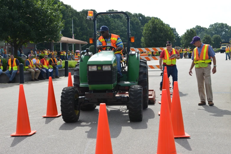 some people in safety vests on a green tractor