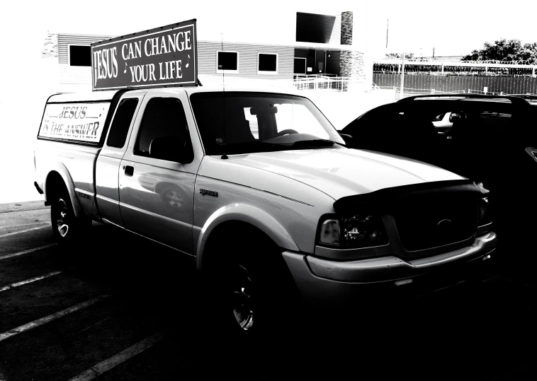 two trucks are parked in the lot and one is black and white