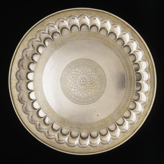 a round silver plate with intricate design