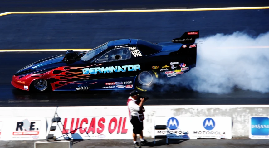 a drag car smoking out smoke on a race track